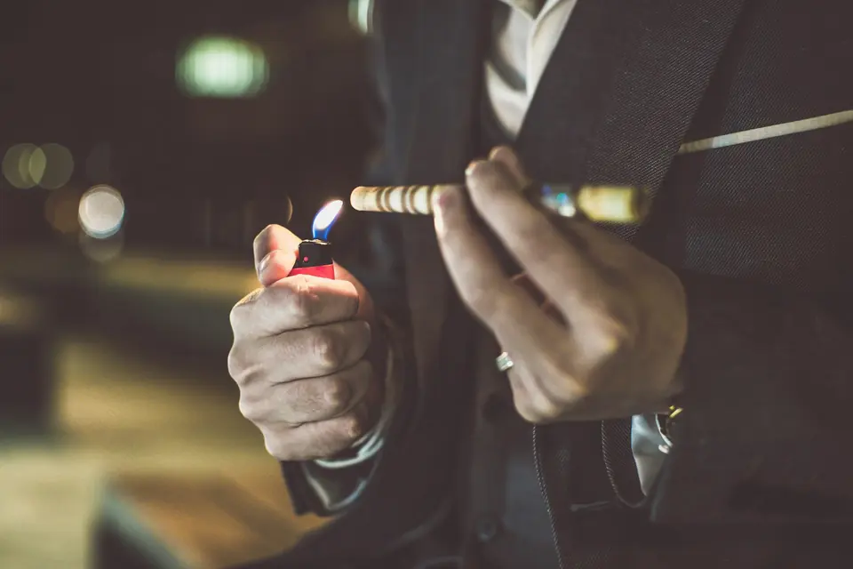 Invitado encendiendo un puro en una recepción de boda